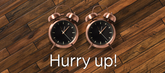two alarm clocks with message HURRY UP! on wooden background
