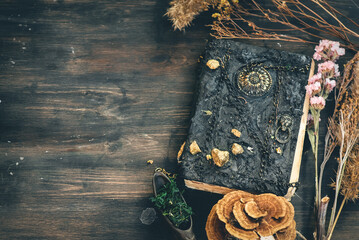 Magic potion bottles, spell book and dried plants on the witch doctor table. Witchcraft.