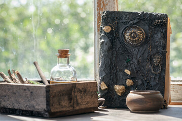 Magic potion bottles, spell book and dried plants on the witch doctor table. Witchcraft.