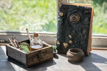 Magic potion bottles, spell book and dried plants on the witch doctor table. Witchcraft.