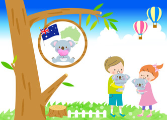 青空のオーストラリアでかわいいコアラを抱っこする笑顔の男の子と女の子
