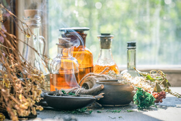 Magic potion bottles and dried plants on the witch doctor table. Witchcraft.