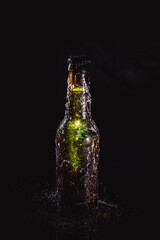 green beer bottle with frost on a black background