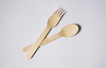 Flat lay concept of a bamboo fork and spoon on white background, plastic-free