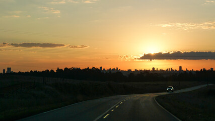 Sunset over PR-513 road, with Ponta Grossa's cityscape on background. Paran&aacute;, Brazil