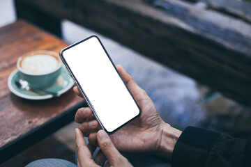 cell phone mockup image blank white screen.woman hand holding texting using mobile on desk at coffee shop.background empty space for advertise.work people contact marketing business,technology