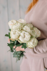 Amazing bouquet of white peonies for the bride for the wedding in the hands of a girl