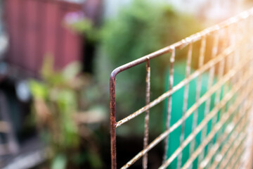Selective focus at corner of old and rusty mesh with lighting effect.