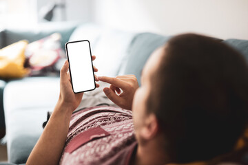 Smartphone blank screen in male hand on the background of home interior