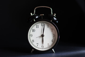Alarm clock on a black background.