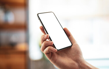 Man using smartphone frameless mockup blank screen in home interior