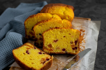 Slices of delicious butter cake or pound cake with dried apricots on dark background. Homemade bakery concept.