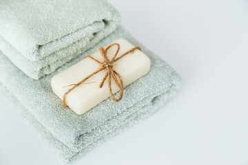 Solid soap corded on bath towels on white background with copy space.
