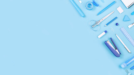 Assorted office and school white and blue stationery on pastel background as border. Flat lay...
