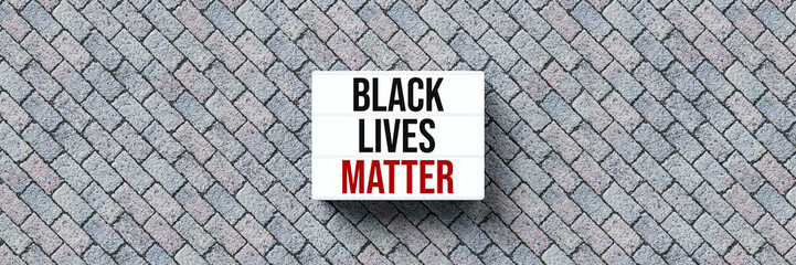 lightbox with message BLACK LIVES MATTER on stone pavement background