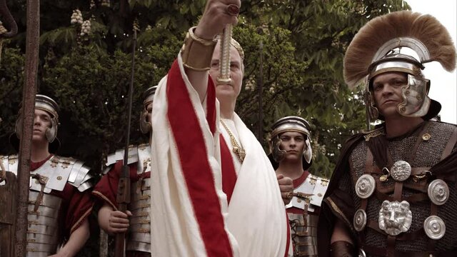 Emperor Surrounded By Soldiers Holds Out Scepter And Gives An Order