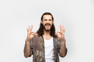 Laughing fun fellow carefree guy shows gesture ok. Hipster traveler stylish carefree man on a white studio background, people lifestyle