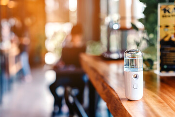 Alcohol nano mist sprayer for hand cleaning to prevent the spread of the corona virus (Covid-19) placed on the table to serve customers before buying in the coffee shop. Modern health technology.