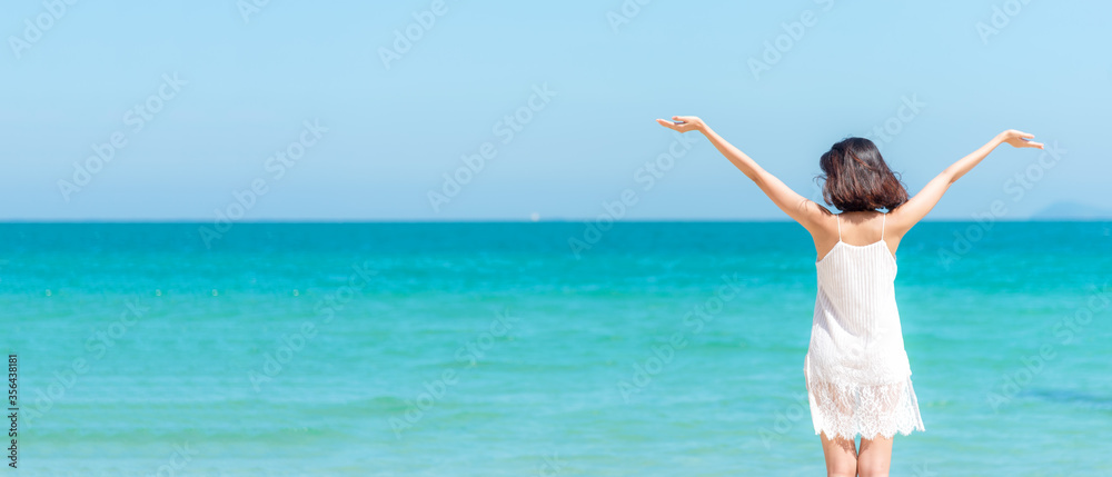 Wall mural summer vacation. lifestyle woman raise arm and hand on wave relax and happy on beach tropical outdoo