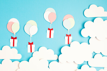 Papercut balloons and Gift Box floating in blue sky with clouds. Happy Bithday, Merry Christmas festive poster. Greeting card with paper craft