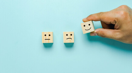 Top view of  Hand holding of Happy icon on cube blocks about rating feedback of survey from...