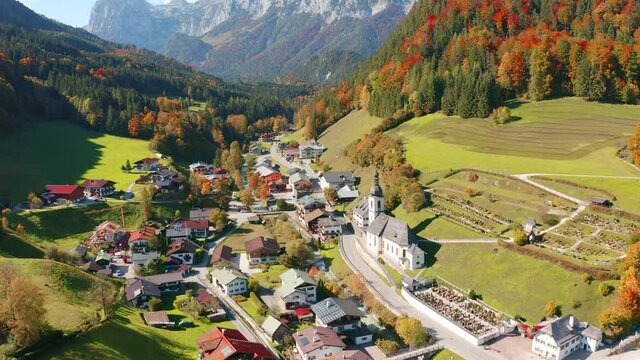 4k drone forward video (Ultra High Definition). Picturesque autumn scene of Ramsau bei Berchtesgaden village with St. Sebastian Church. Superb morning view of Bavarian Alps, Germany.