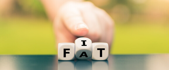 Hand turns dice and changes the word "fat" to "fit".