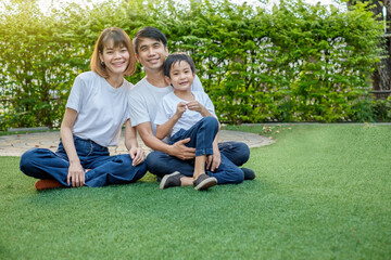 Fototapeta premium Happy asian family father mother and son sitting and play at home garden. Good mood moment time.