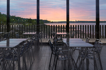 East view of the St. Lawrence River and St-Michel-de-Sillery church seen through a deserted restaurant during a beautiful pink cloudy dawn, Sillery area, Quebec City, Quebec, Canada