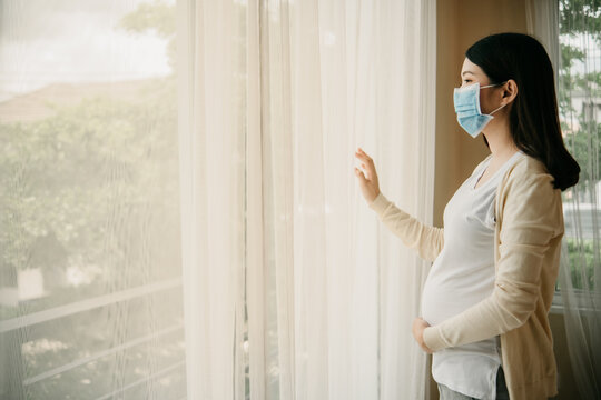 Asian pregnant women beautiful girl wearing medical masks due to illness, dizziness. Healthy pregnancy concept. Protect Covid 19 Do not leave the house