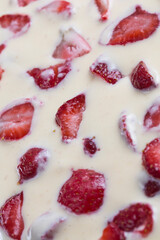 filled frame background wallpaper shot of strawberries on the surface of a milky white vanilla cheese cake cream liquid