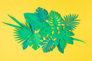 Paper tropical leaves over pastel background. Summer exotic vacation, greeting card mockup. DIY project idea. Top view flat lay