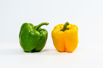 Yellow and Green Bell Pepper Wet from Water Drop on Isolated White Background.