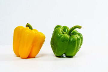 Yellow and Green Bell Pepper Wet from Water Drop on Isolated White Background.