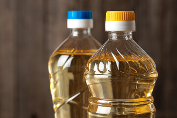 Olive oil bottle on wooden table, close up.