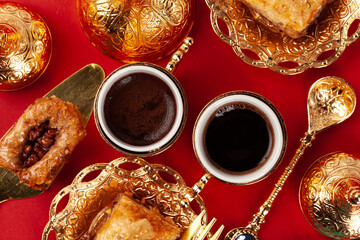 Turkish baklava and coffee in oriental dishware on red background