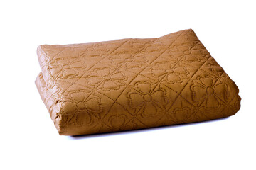 Quilt on a white background. Blanket is neatly folded. Warm brown blanket. Bedding with a floral pattern. Silhouettes of flowers are depicted on a blanket. Quilt for shelter during sleep.