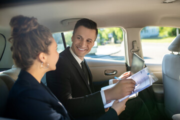 Attractive man signing document and woman in car