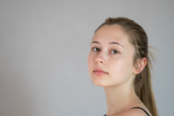 Studio portrait of a cute adolescent looking at the camera against a grey background