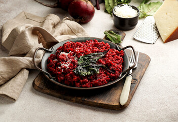 beetroot risotto with hard cheese, caramelized leaves,  dark black background