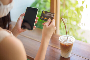 Close up woman hand is holding credit card and cellphone , shopping online concept