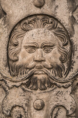Fototapeta na wymiar Generic simplified bearded man's face carved from a flat piece of grubby stone shot straight on.