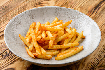french fries in a plate on a wooden background