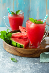 Cold Watermelon Smoothie. Summer Watermelon drink and slices of watermelon on a light stone table. Copy space.