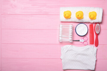 Baby clothes on a pink background with accessories. Place for text. Flat lay.