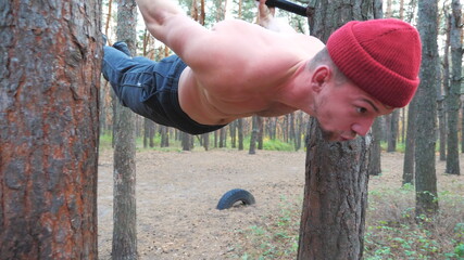 Strong man showing some gymnastics stunts on horizontal bar. Muscular guy doing gymnastics...