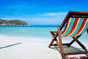 Beach chairs on a sandy beach by the ocean, the concept of relaxation, traveling on a tropical island, relaxation with beautiful views of the bruise sea and blue sky