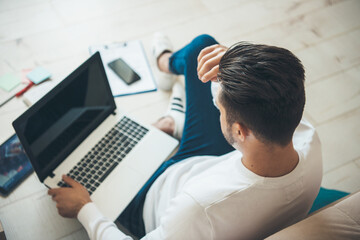 upper view photo of a caucasian businessman working at the computer with free space on the floor...