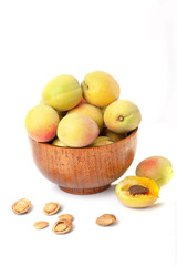Fresh ripe apricots in wooden bowl isolated on a white background.