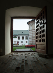 Fototapeta premium Tranquil atmosphere at Cozia Monastery, the 14th century architecture, through the huge wooden door.